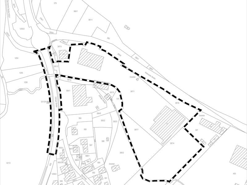 Die Karte zeigt ein Gebiet mit verschiedenen nummerierten Parzellen, umrahmt von einer dicken, gestrichelten Linie und durchzogen von Straßen und Wegen.